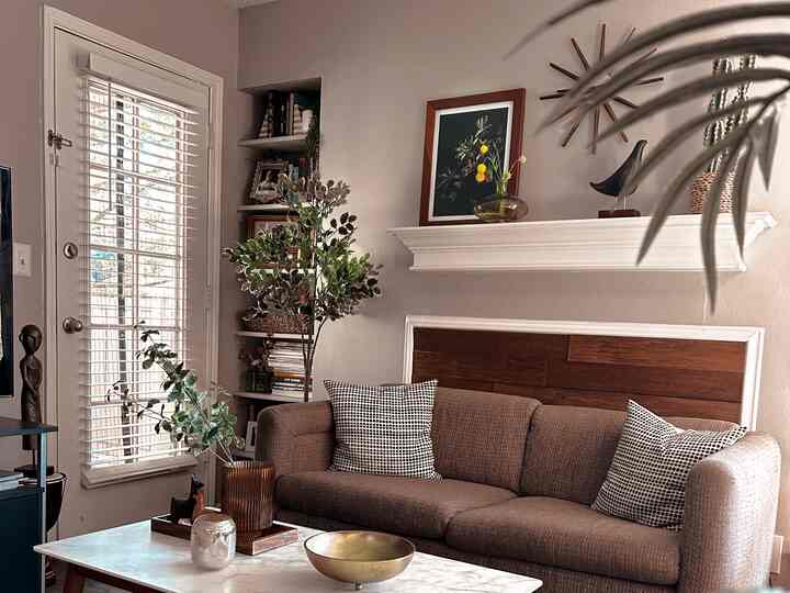 Natural color and wood tone living room featuring a brown sofa, coffee table, and wall art creating a cozy atmosphere