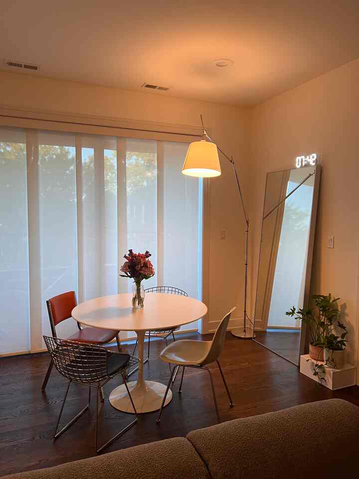 White and wood tone dining room featuring a round dining table with mixed chairs in a cozy setting