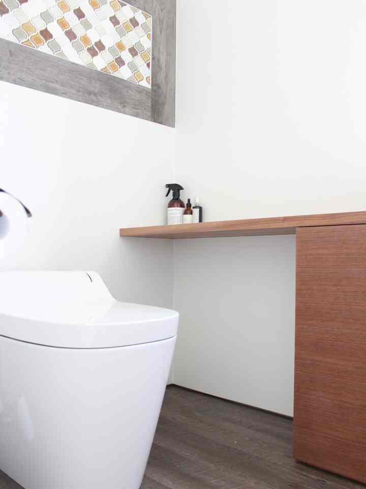 Natural tone restroom with wood shelf and Corabel tile accent on white walls