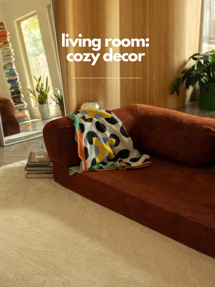 Warm brown and ivory toned living room featuring teddy sofa with patterned throw and light beige rug creating a cozy atmosphere