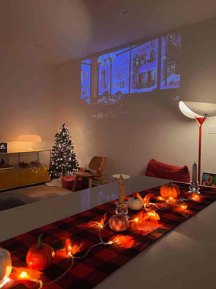Warm red and orange toned kitchen and living area featuring a kitchen island decorated with cozy fall and winter accents