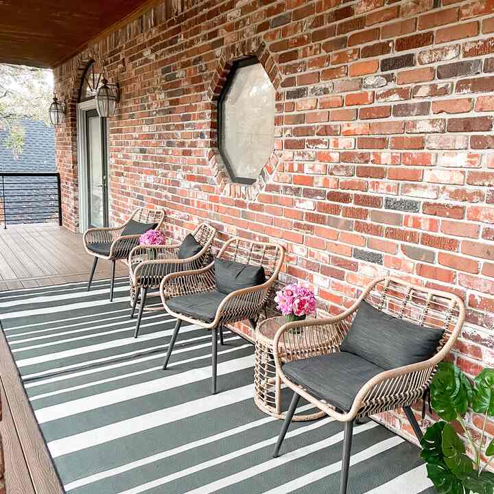 Natural wood-tone flooring balcony with rattan chairs arranged neatly, creating an inviting outdoor relaxation space