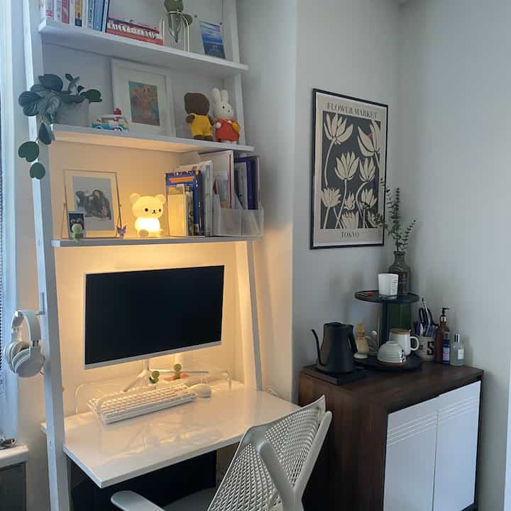 White and brown toned home office featuring desk with computer and coffee setup in a neat workspace