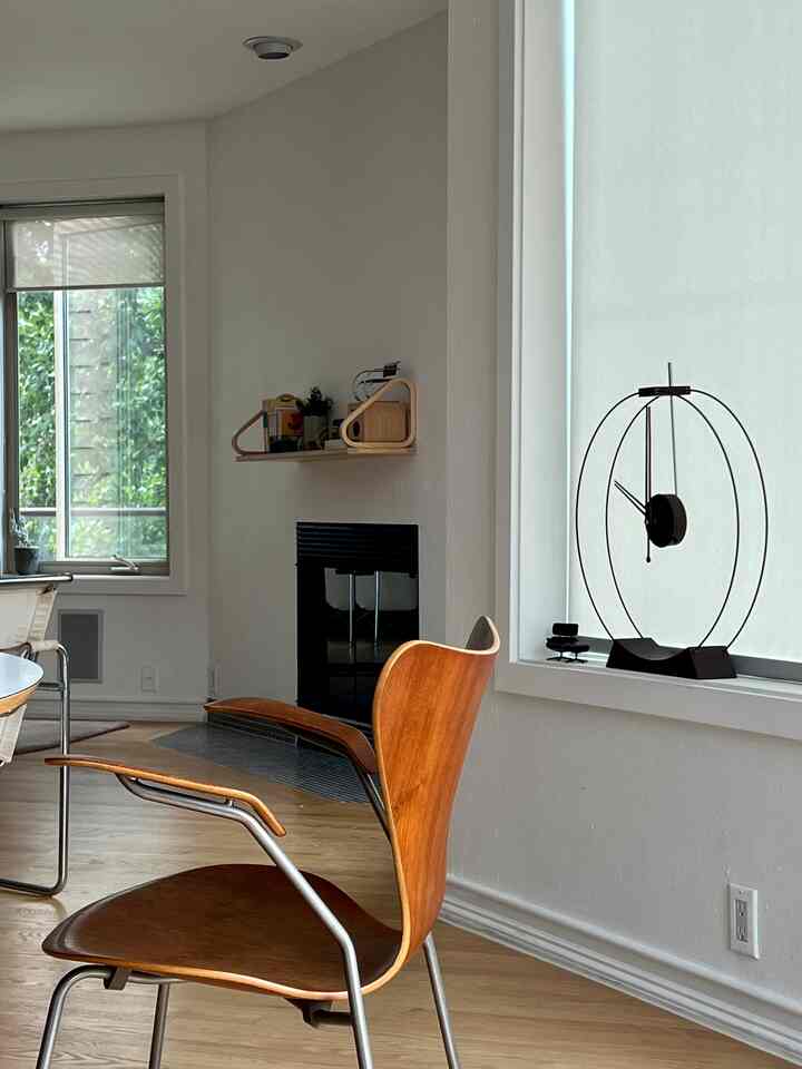 Mid-century modern living room featuring a wood tone armchair and white walls with minimal décor