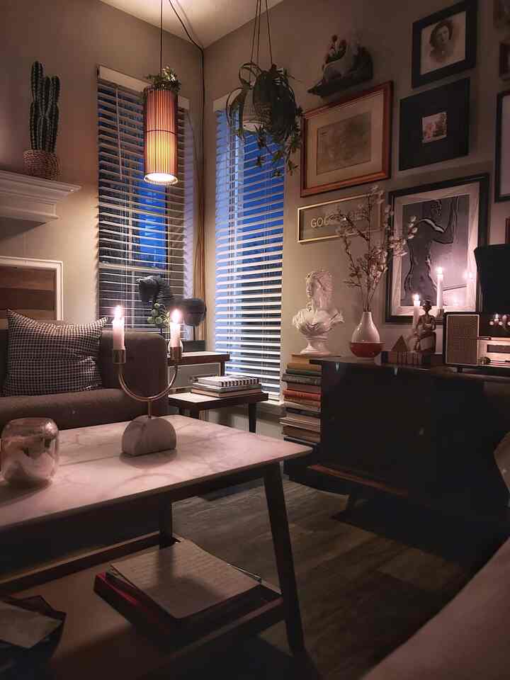 Warm brown and white toned living room featuring a marble coffee table, sofas, wall art, and plants creating a cozy atmosphere