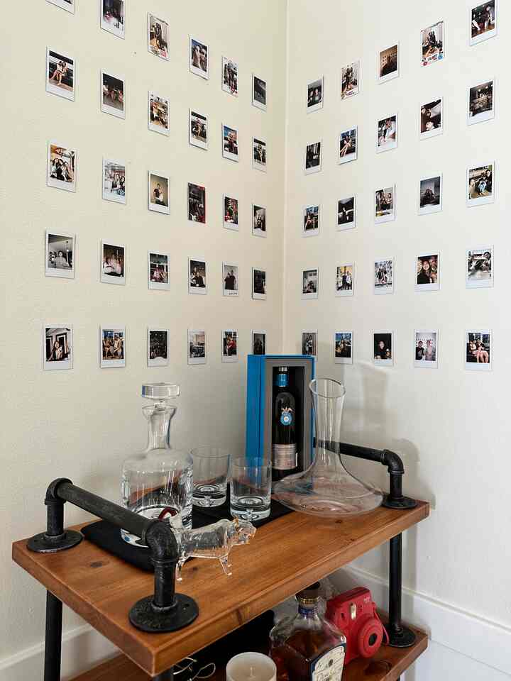 One of my favorite ways to display our polaroids 📸 #barcart #diningroom #diningroominterior #wine #photozone #photointerior 