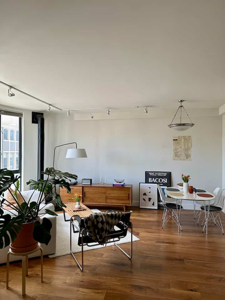 White walls and wood-tone flooring in a warm, modern living room featuring Mid-Century Modern furniture