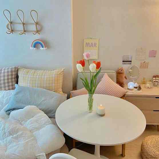 Beige and white toned living room featuring a round coffee table and assorted cushions creating a cozy natural ambiance