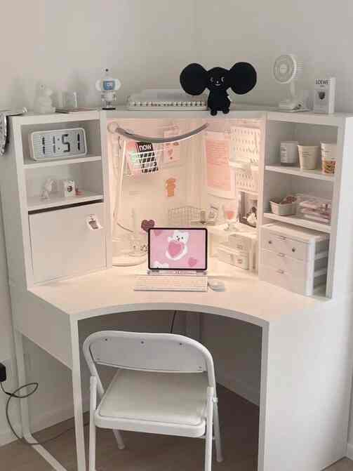 White-toned small room corner featuring a compact home office with white desk, chair, shelving storage creating a clean atmosphere