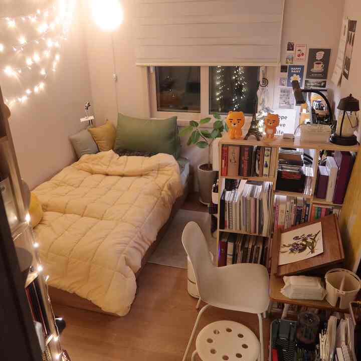 Beige-toned compact single household bedroom and home office space featuring a stool and desk with natural, cozy atmosphere