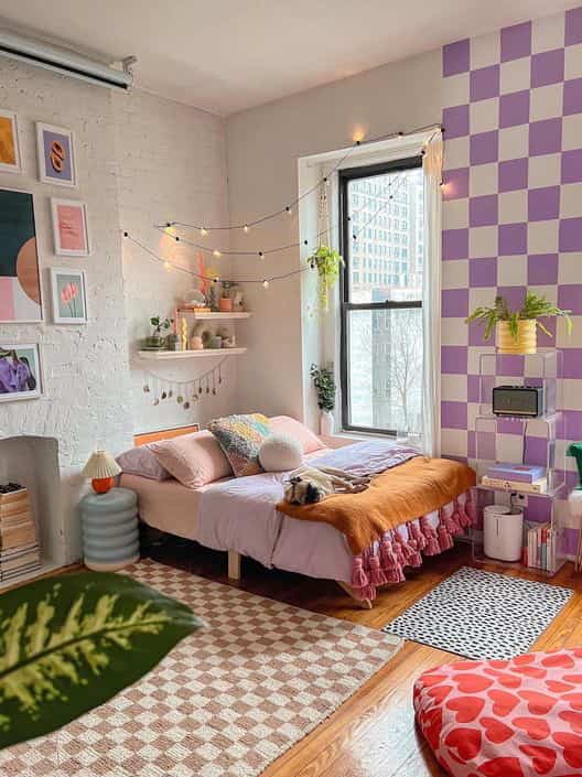 A white and purple toned bedroom featuring a bed and rugs, creating a cozy bohemian style atmosphere