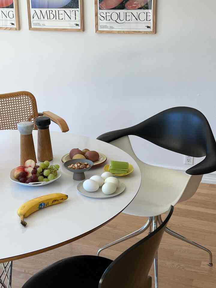White and brown toned dining room featuring modern armchair and plates on a clean table