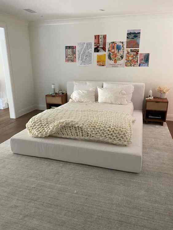 White and natural toned bedroom featuring a simple bed frame and two nightstands in a minimalist setting