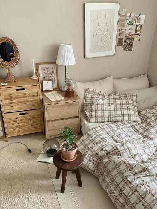 Brown and natural toned bedroom featuring plaid duvet cover, wooden nightstand, and chest of drawers creating a cozy atmosphere