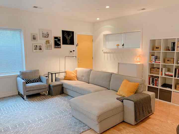 White and gray toned living room featuring a two-seater sofa and armchair with a simple modern cozy atmosphere