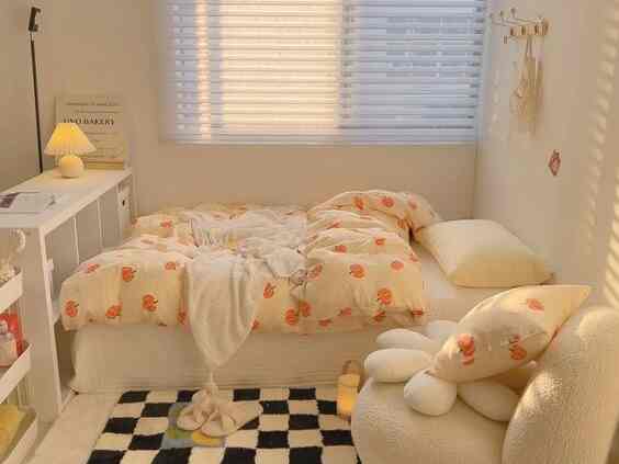 A bedroom bathed in warm natural light featuring pumpkin-patterned bedding and cushions with a cozy natural atmosphere