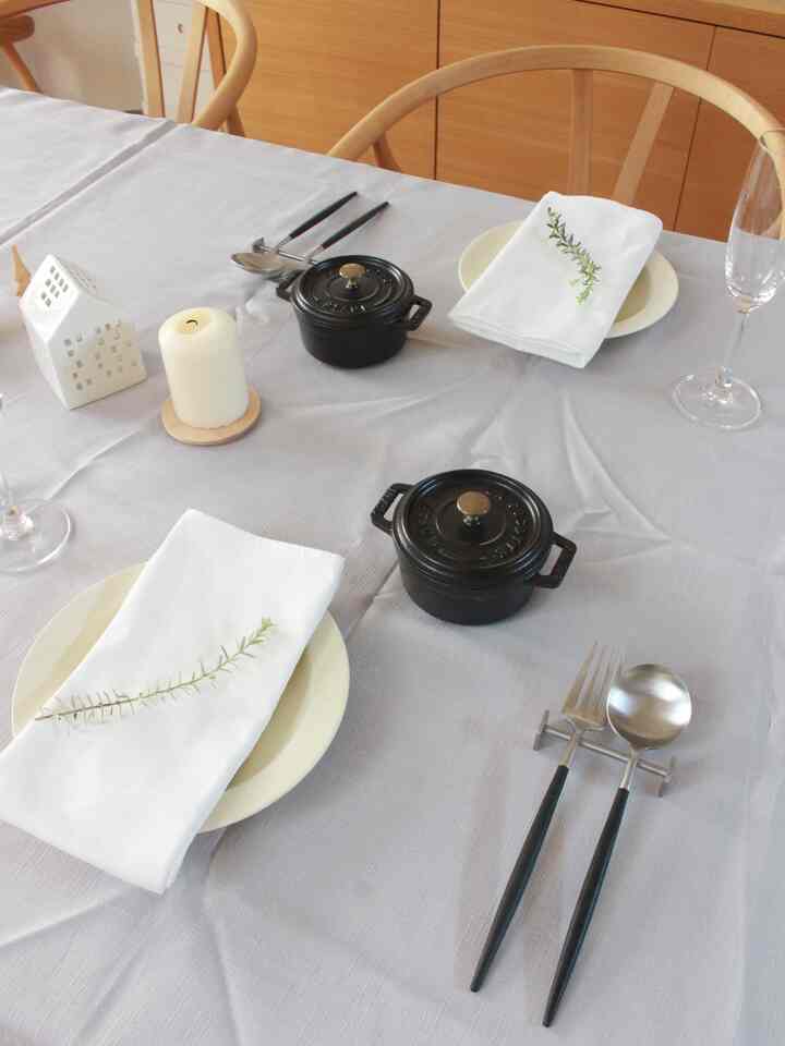 白と木目調の調和が美しいダイニングにて、特別な日のために整えられたテーブルと小物が配置された雰囲気のあるインテリア