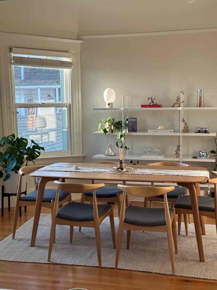 Light brown wood tone natural dining room featuring oak dining table and chairs with simple, warm atmosphere and plants