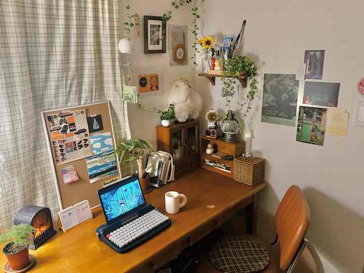 Wood tone home office featuring wooden desk, office chair, plants, and framed art creating a cozy workspace