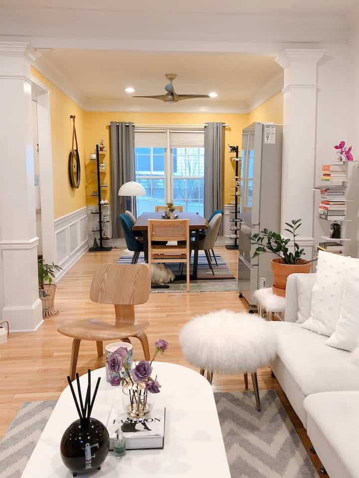 Natural modern living and dining room featuring yellow walls, white sofa, and wooden furniture with cozy atmosphere