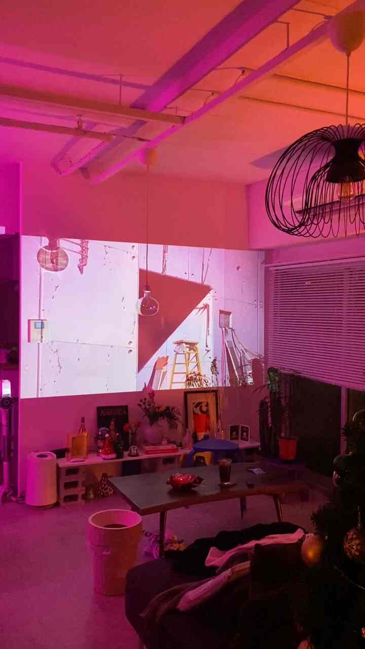 Pink-lit studio apartment living room featuring a mid-sized sofa and coffee table with a modern vibe