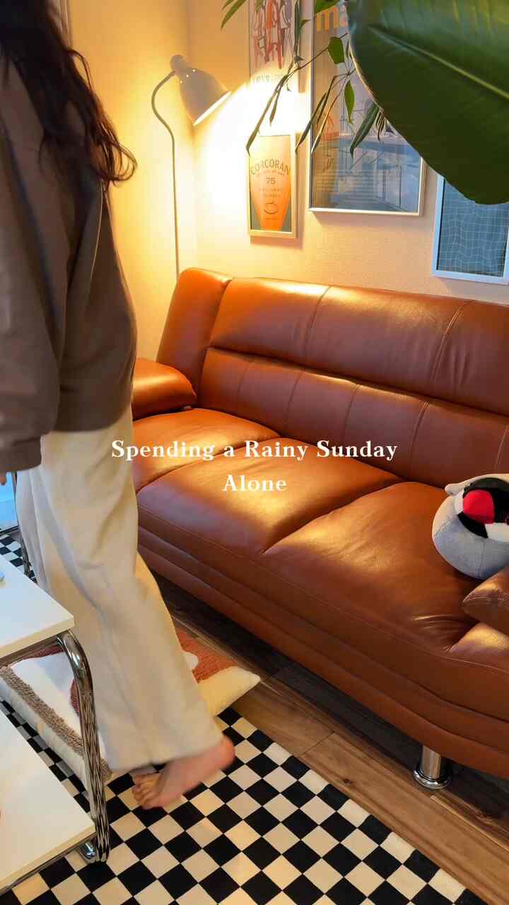 暖かいブラウンの革ソファとチェッカーボードラグが配置された居心地の良いリビング