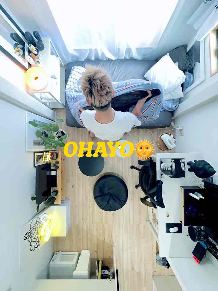 白と木目調の調和が取れた6畳のワンルーム寝室、デスクが配置された一人暮らしの空間