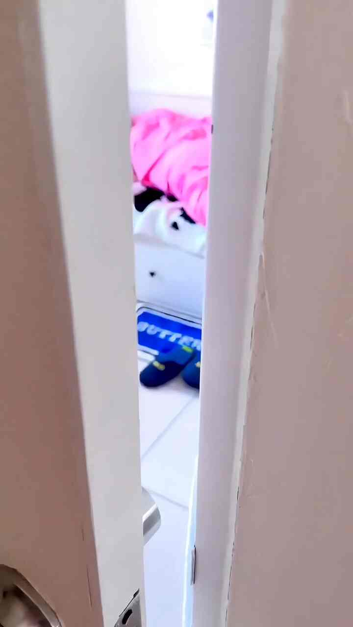 明るいホワイトトーンの壁とピンクの寝具が配置されたコンパクトな寝室の内部