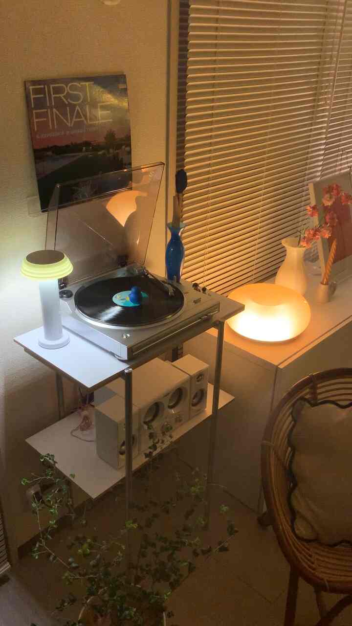 Cozy small living room with warm lighting featuring white furniture and a turntable