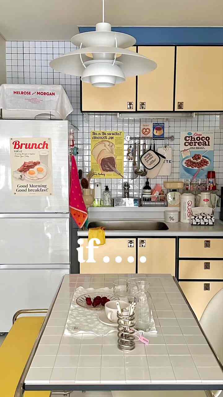 白とベージュの色調のキッチンダイニング、タイルのテーブルと黄色い椅子が配置されたモダンな雰囲気のインテリア