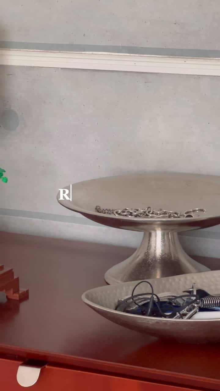 ナチュラルトーンの1Kワンルーム、ソファとキャビネット、植物が配置された雰囲気のあるインテリア