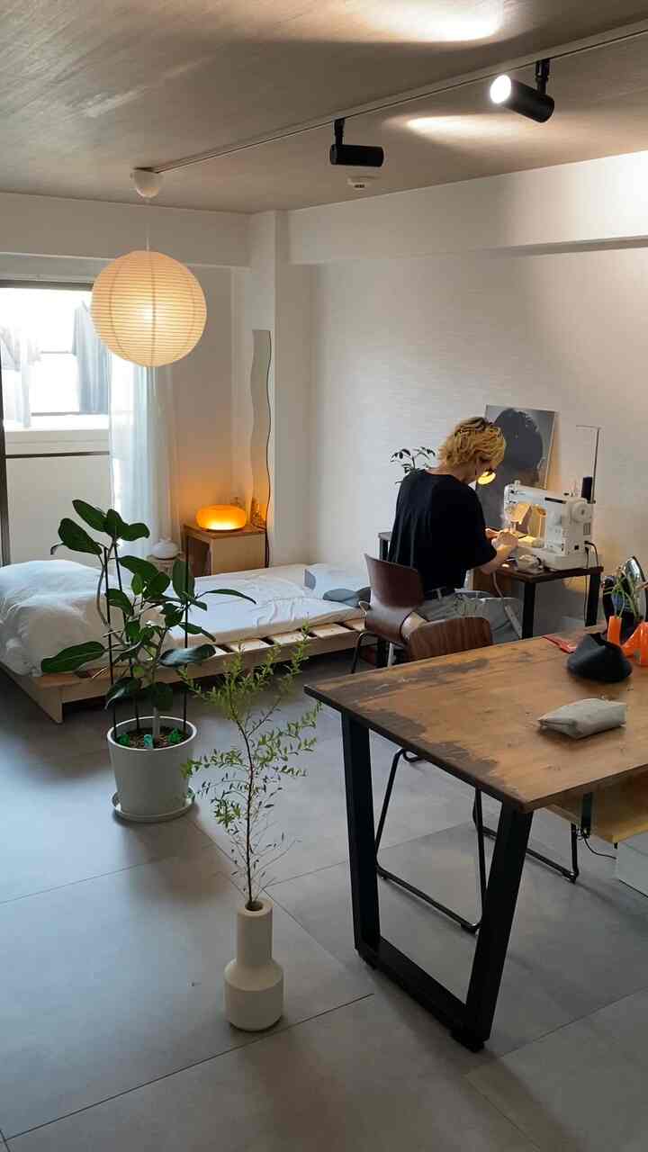 ナチュラルな色調のワンルーム寝室とワークスペースが調和したモダンなインテリア、木製家具と植物がポイントの温かみある空間