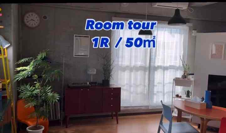 Warm wood-toned flooring and large windows define a Nordic-style studio apartment living and dining area for a single household