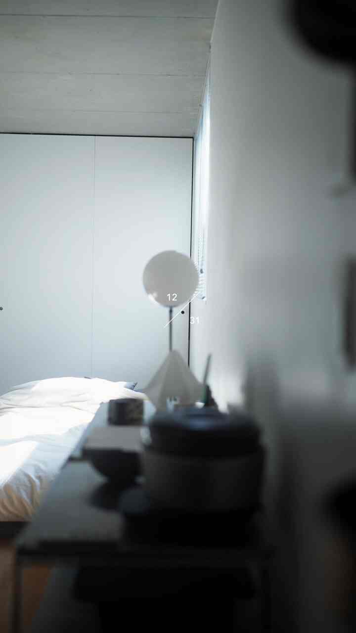 白とナチュラルカラーの寝室、ミニマルでシンプルな家具と自然光が調和した落ち着きのある空間