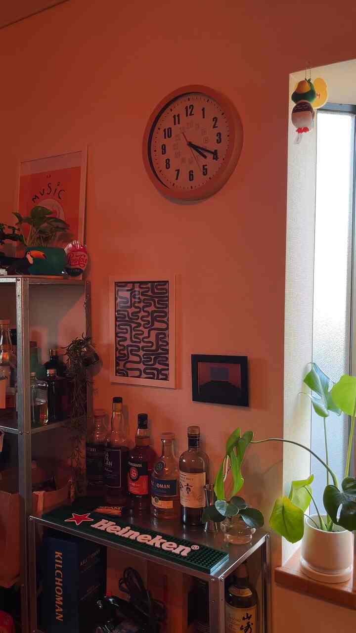 暖かみのあるブラウン調のホームバー空間、メタルシェルフと多様なウィスキーボトル、植物が調和した雰囲気のあるインテリア