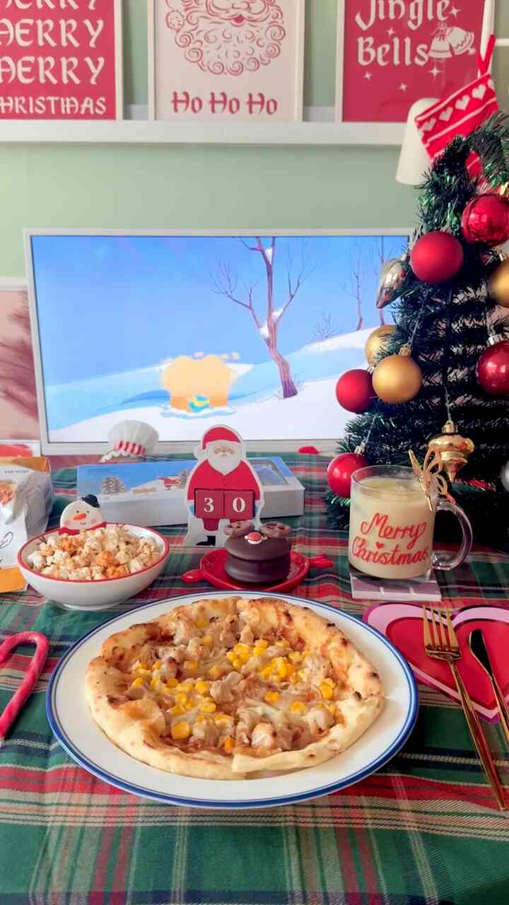 赤と緑の色調のリビング、クリスマスツリーと飾り、ピザやスナックが並ぶ温かみのあるホームパーティースペース