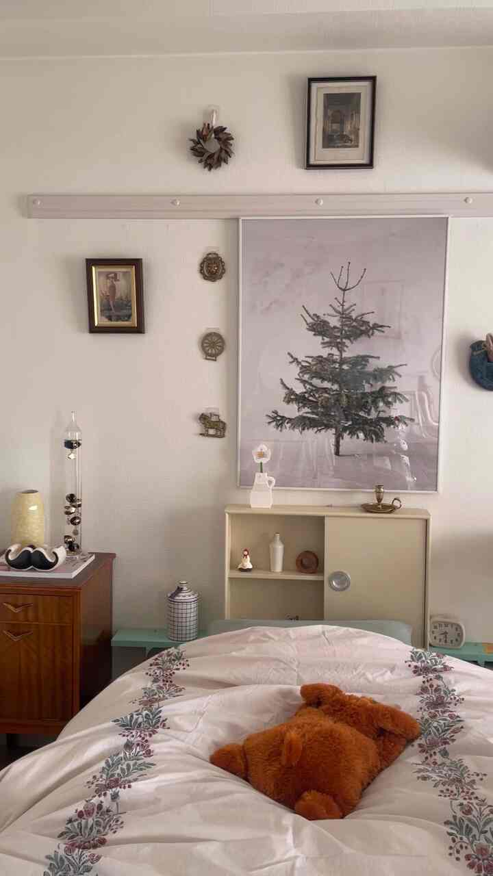 White-walled vintage-style single household bedroom featuring floral bedding and a plush bear, creating a cozy atmosphere
