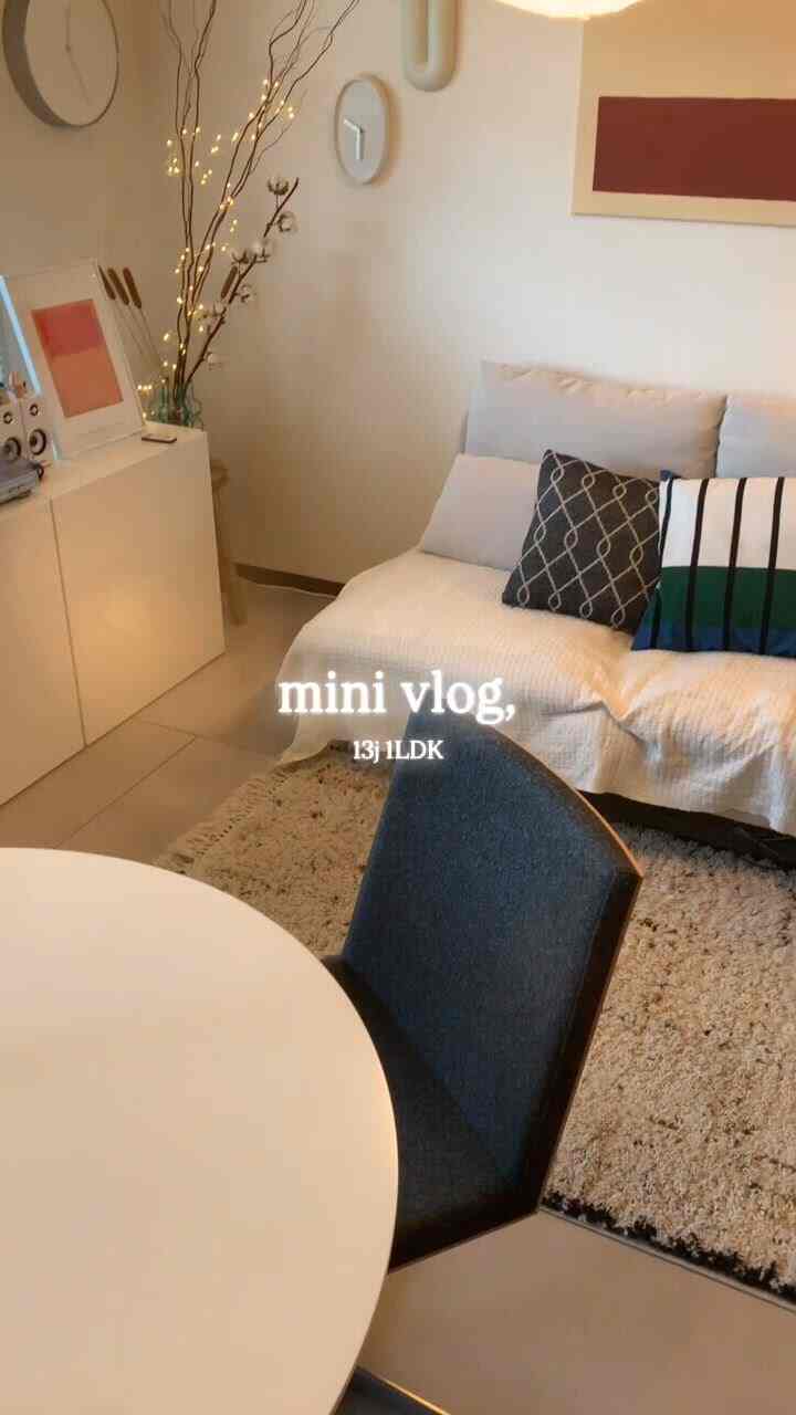 ベージュとアイボリーのトーンの1LDKリビング、ソファと丸いダイニングテーブルが配置された落ち着いたナチュラルなインテリア