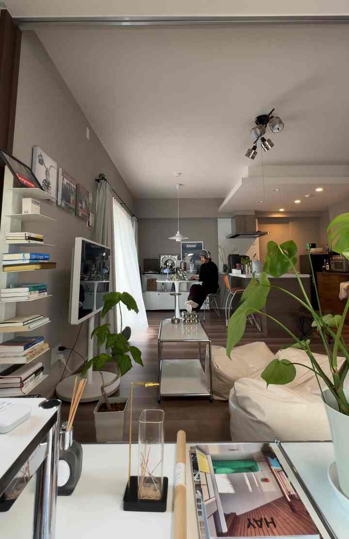 白と茶色の色調のリビング、カフェ風のテーブルとビーズクッションが配置された雰囲気のある空間