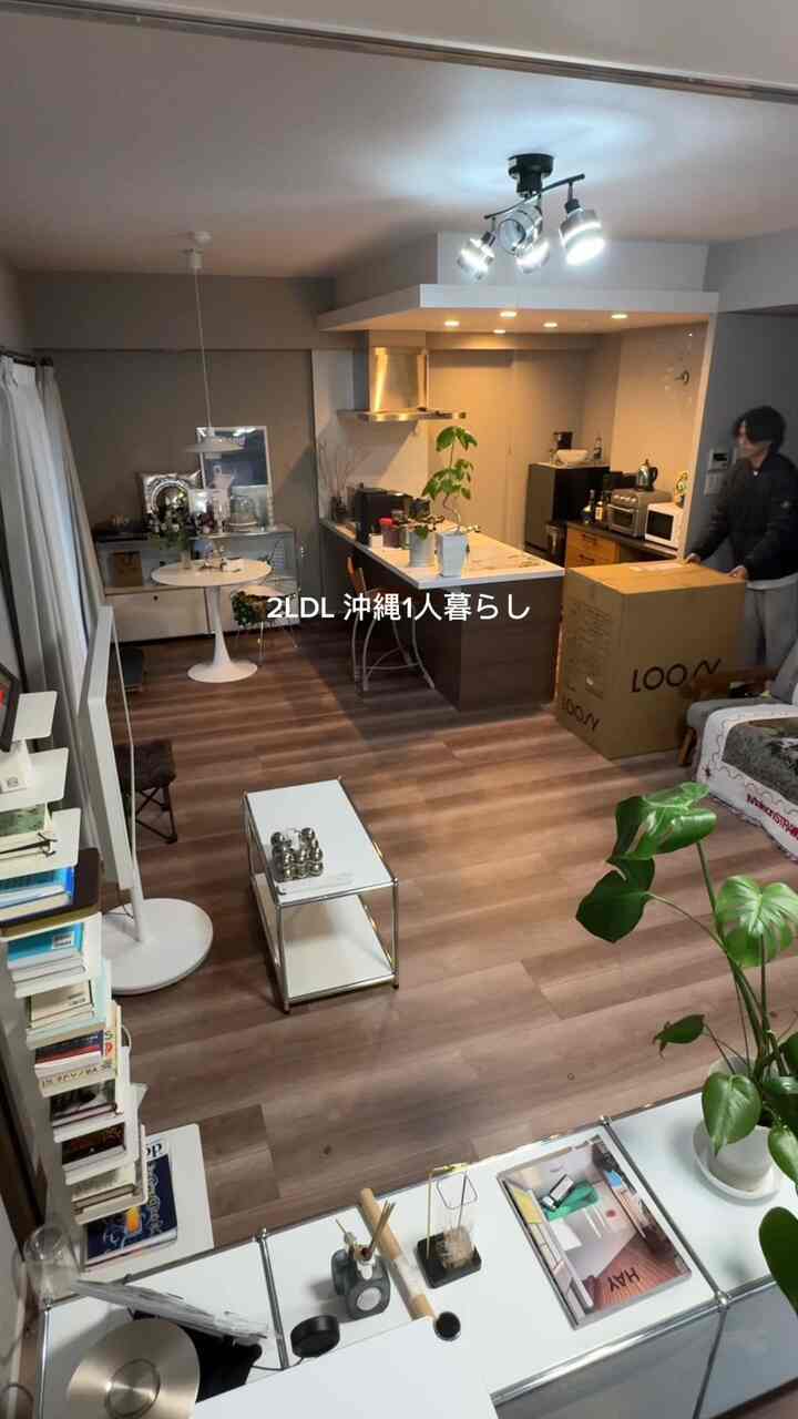 Modern single household studio apartment featuring brown wooden floors and white furniture in living and kitchen area