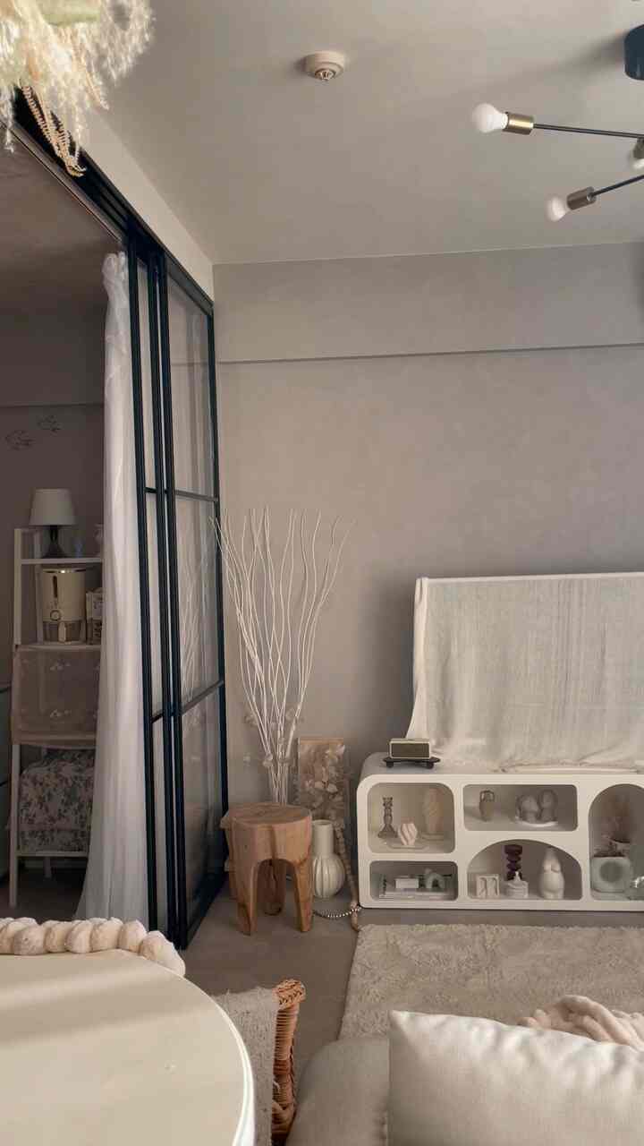 Beige and natural toned living and kids' room space featuring a transparent glass sliding door and modern furniture for a cozy atmosphere