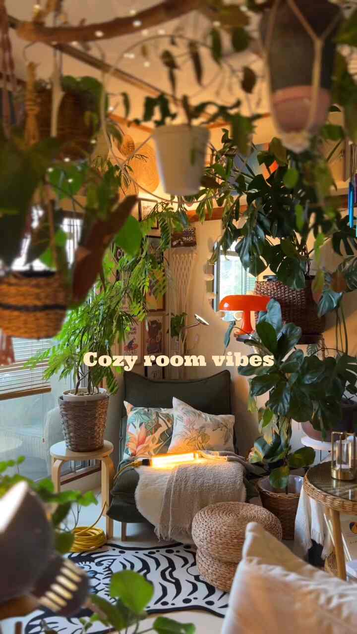 グリーンとナチュラルカラーのリビングルーム、多数の植物と照明が配置された雰囲気のあるインテリア