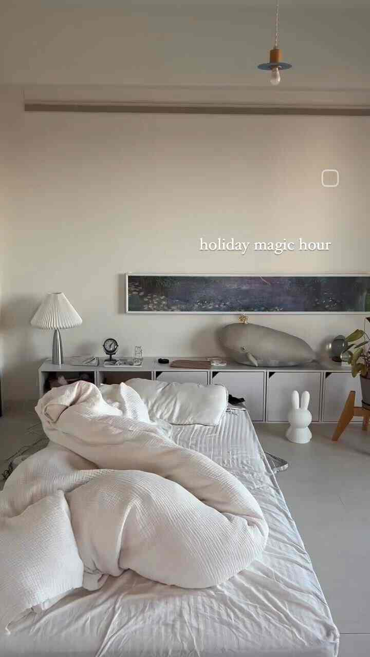 ナチュラルカラーの1LDK寝室、中央に白いベッドと掛け布団カバーが配置された落ち着いた空間