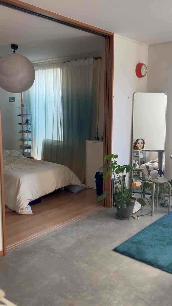 白と青のトーンの1LDK空間、スライディングドアで区切られた寝室とリビングがある落ち着いたインテリア