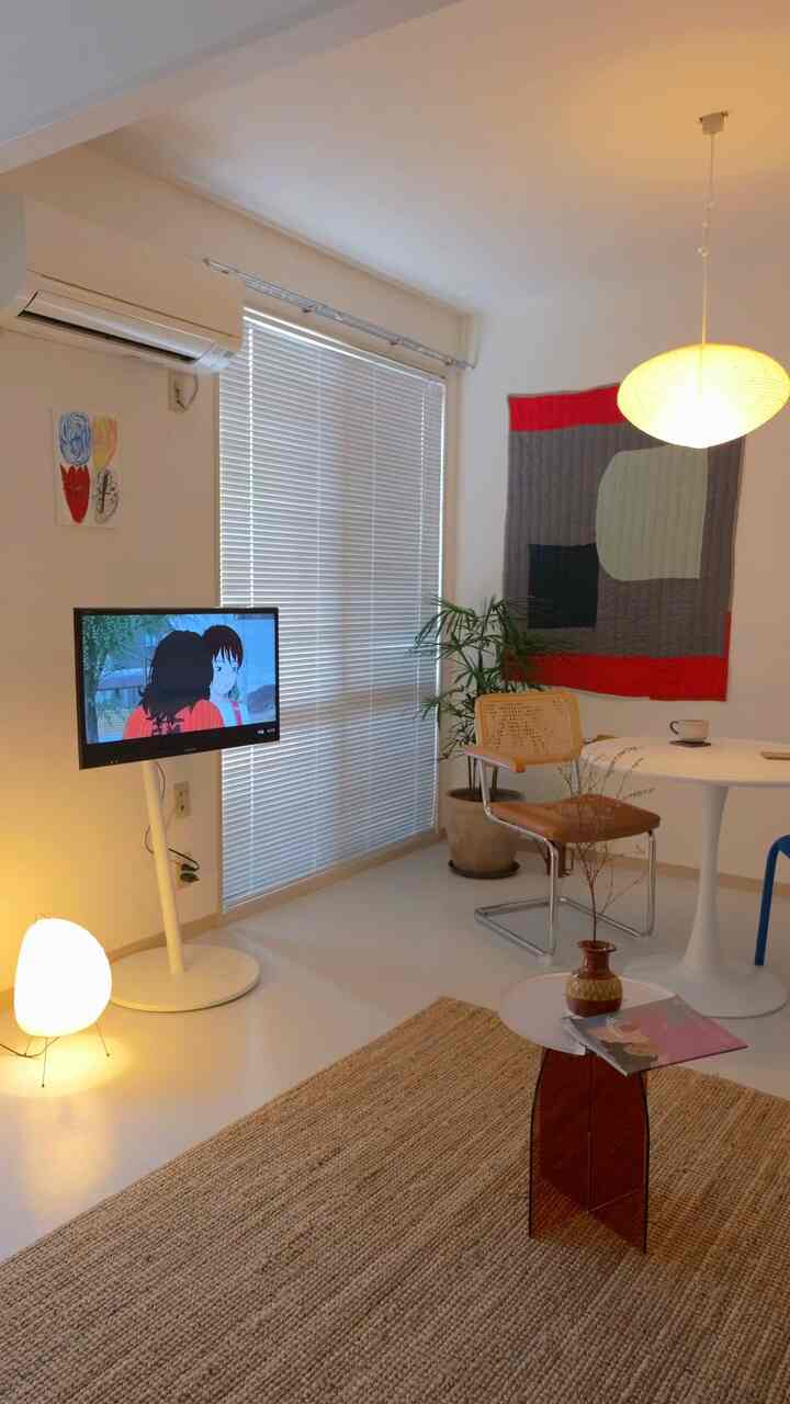 ナチュラルカラーでシンプルなスタイルのリビング・ダイニング、ラタンのダイニングチェアとラグ、ペンダントライトが配置された温かみのある空間