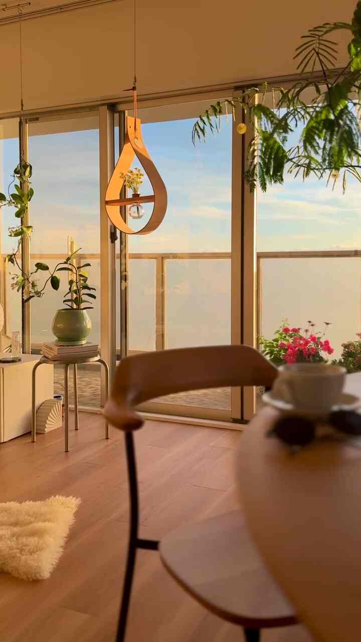 Warm wood tone living room with visible balcony featuring natural modern home cafe atmosphere