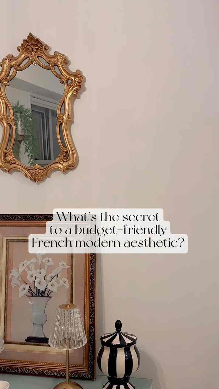 Ivory wall with gold ornate mirror, floral painting, and table lamp in a French modern styled space