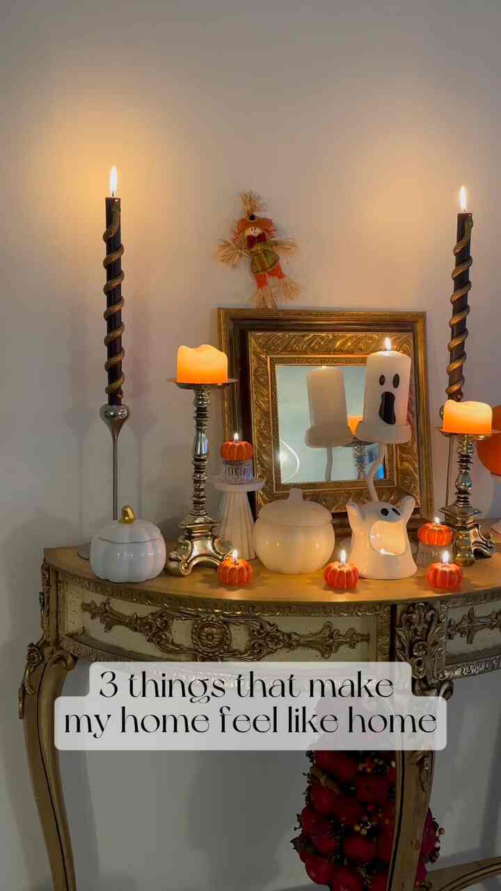 White-walled living space featuring a French Country console table adorned with fall-themed candles for a cozy atmosphere