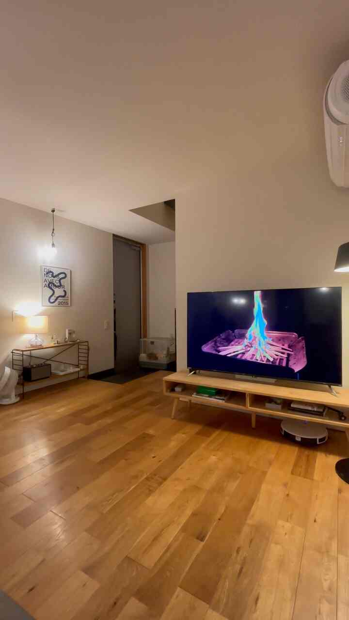 ナチュラルな木目調の床とシンプルなテレビ台が配置された北欧風リビングのインテリア