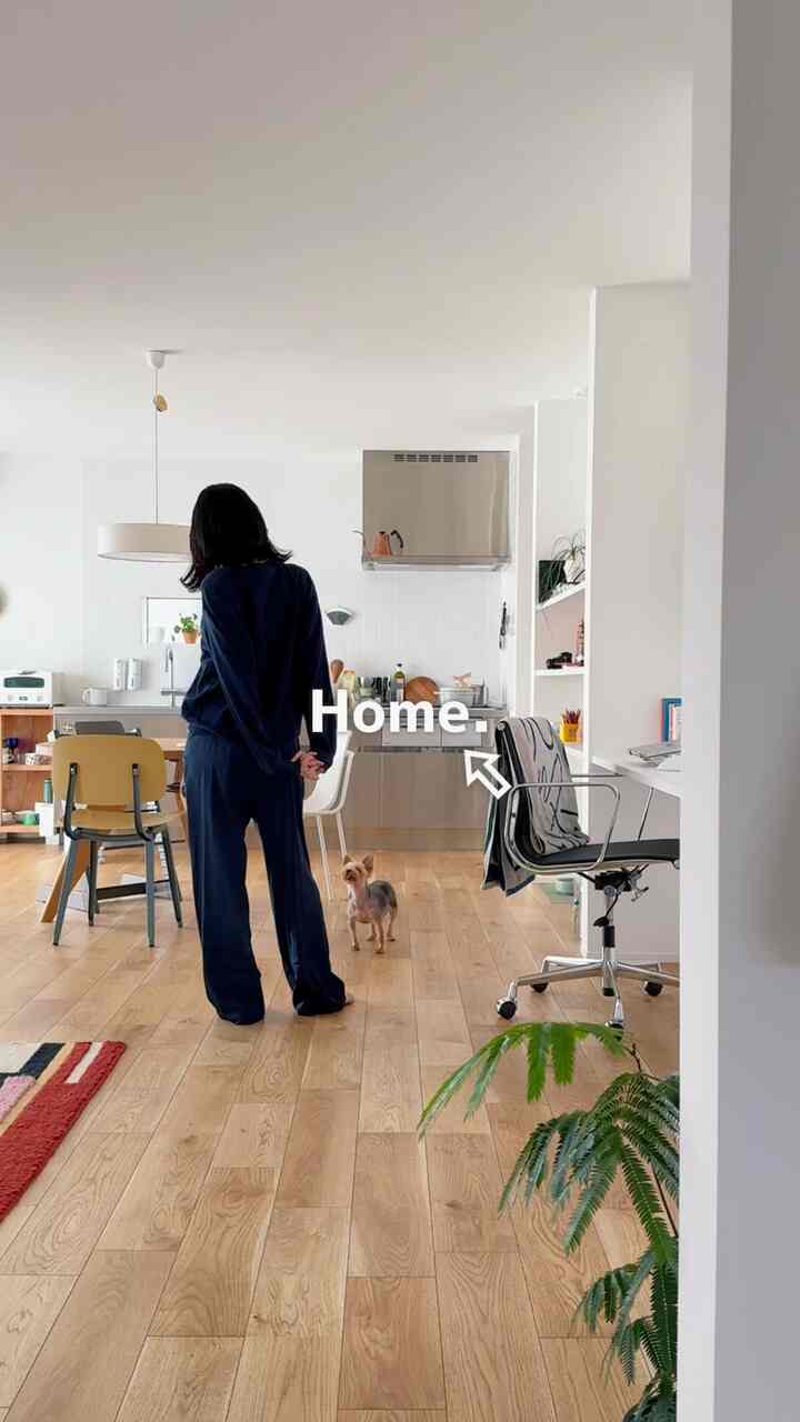 白い壁と木目調の床が調和したリビング兼キッチンスペース、犬とおうちカフェ、ホームオフィスの雰囲気が融合した空間